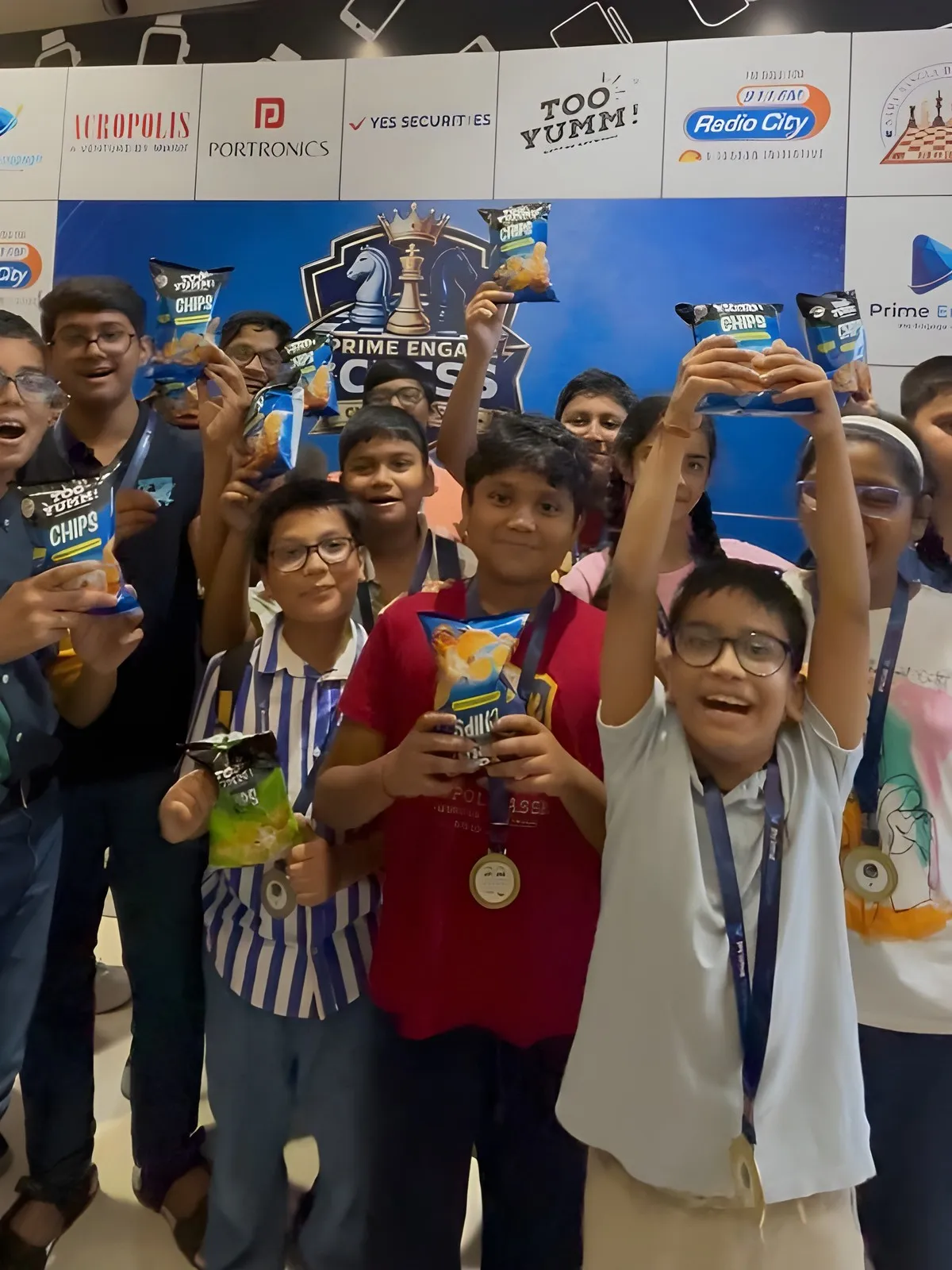 Young players holding up Too Yumm! snack packs after the Kolkata round of the Prime Engage Jr. Chess Championship