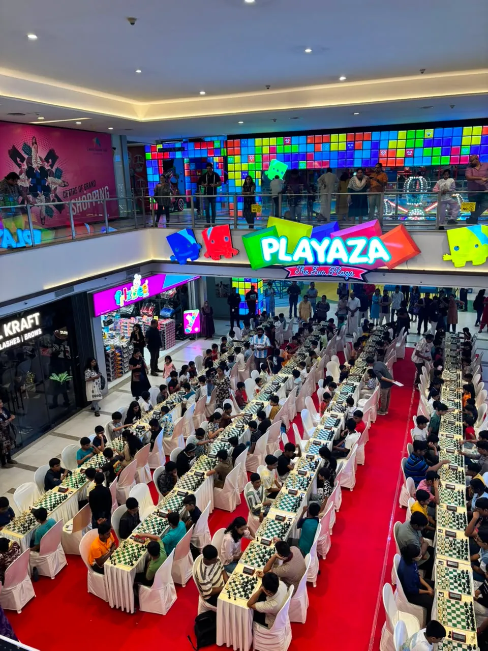 Players at their boards in the Centre Square Mall atrium in Kochi, with the Playaza arches at the far end