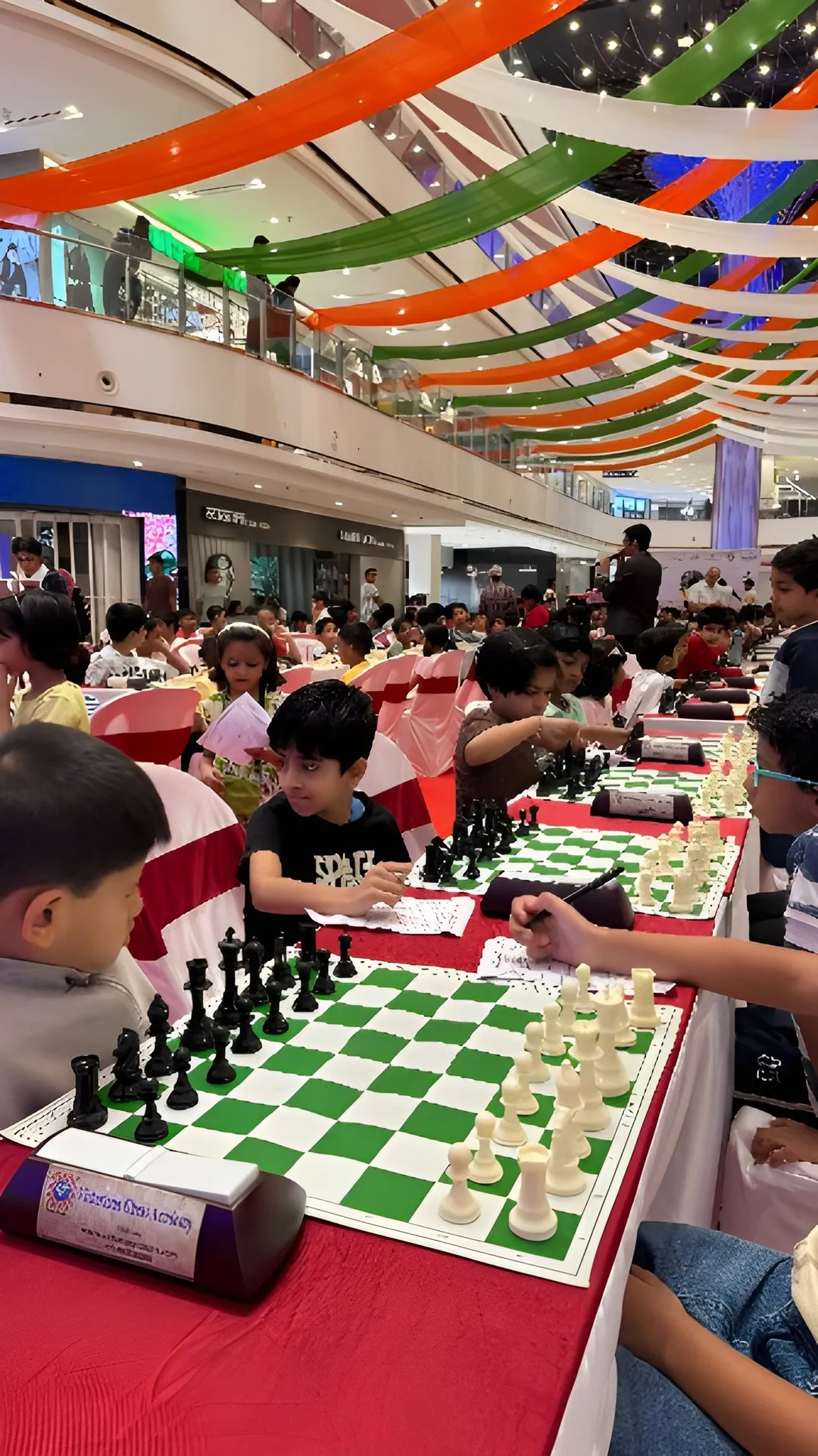 Players at their boards, with the championship backdrop behind.